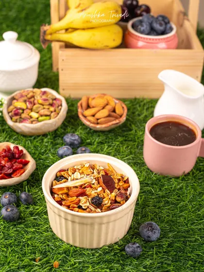 A bowl of granola styled in a vibrant outdoor setting on green grass, emphasizing its natural and healthy qualities.