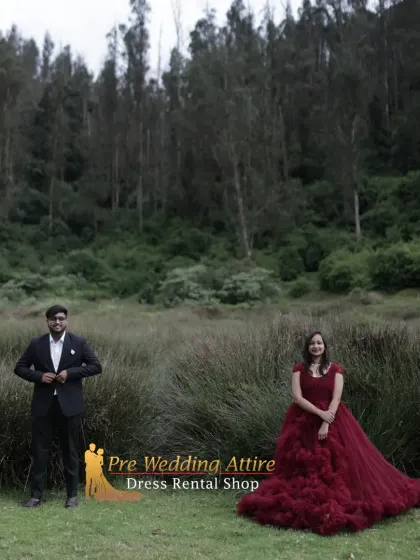 A wide shot of a couple in a field, showing how the volume of the ruffled gown and the sharp silhouette of the suit create a powerful visual against an expansive backdrop.