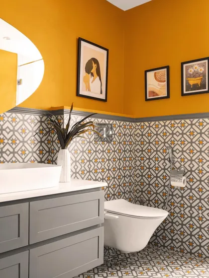 This powder room makes a bold statement with vibrant mustard walls and patterned floor-to-ceiling tiles. The combination of color and pattern creates a cheerful and energetic atmosphere.