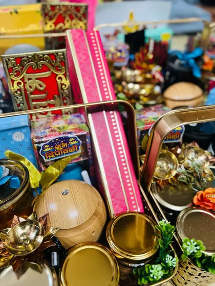 A close-up, dynamic shot of the contents of a Diwali hamper, showing the rich colors and textures of the festive items.