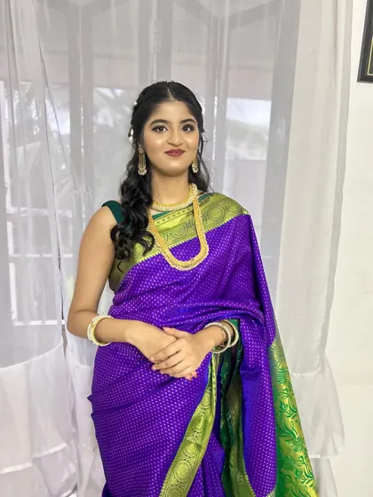 A complete Maharashtrian look for a wedding guest. The purple saree, gold jewelry, and traditional makeup and hair all come together perfectly.