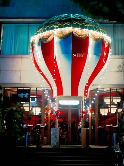 A giant hot air balloon structure installed at the entrance of Gigi restaurant, creating a spectacular and whimsical welcome for the holiday season.