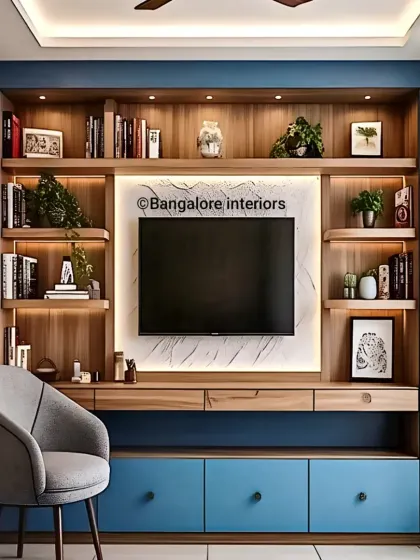 A custom-built TV unit in blue and wood tones, featuring ample shelving for books and decor. The backlit marble panel behind the TV adds a touch of luxury and provides soft ambient light.