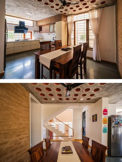 The kitchen and dining area in the Kaustubha Residence. The filler slab ceiling with clay pots is a signature sustainable feature, and the open-plan design connects the kitchen to the rest of the home.