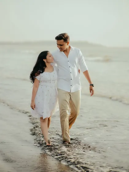 A simple walk on the beach, but with you, it's everything. This candid shot captures the natural interaction and loving gaze between the couple during their pre-wedding session.