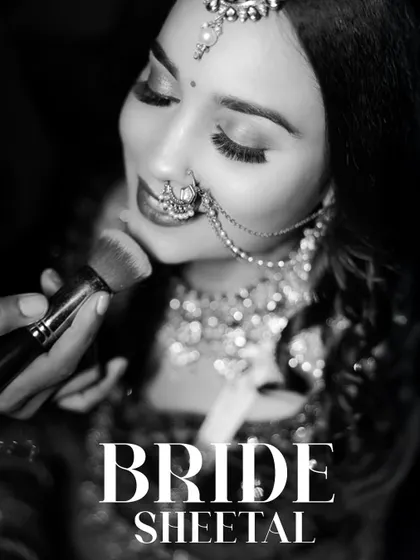 A timeless black and white shot of the bride getting a final touch-up. This behind-the-scenes moment captures the anticipation and excitement of getting ready for the big day.