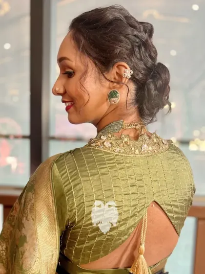 A client looking elegant in an olive green silk and organza blouse with cut edge work and ruffled sleeves.
