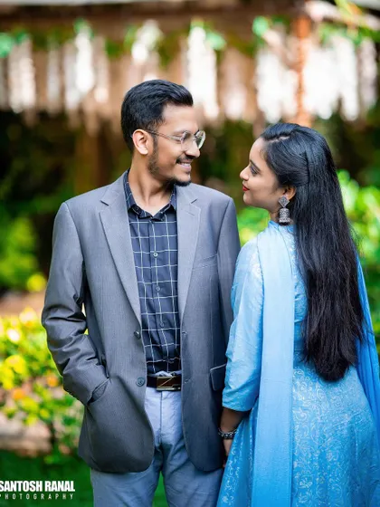 A candid and happy moment between a couple in a garden setting.