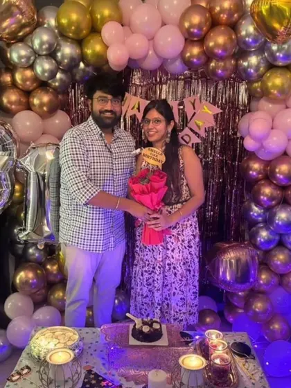 A happy couple celebrating a 31st birthday with our cozy room decoration. The rose gold and pink balloon wall creates a beautiful and intimate backdrop.