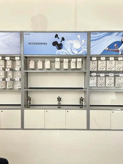 The completed accessories wall at the Vivo showroom in Ahmedabad. The design uses backlighting and clean shelving to make the products stand out.