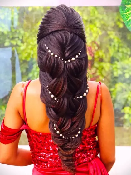 A mermaid braid with beautiful leaf elements and pearl accessories. This style is perfect for a bride who wants a romantic and ethereal look on her wedding day.