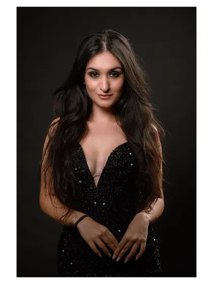 A glamorous studio portrait in a sequined black dress. The model's pose is elegant and sophisticated.