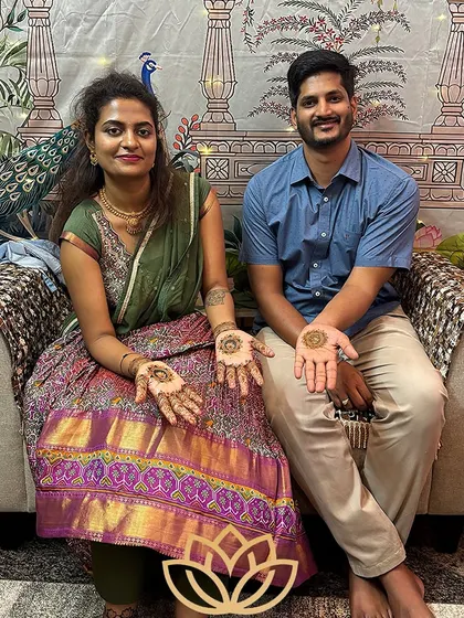 A lovely photo of the bride Rashmi and her groom, both with simple, matching mehendi designs on their palms.
