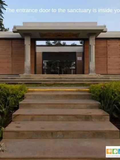 The entrance to a sanctuary space, designed to evoke a sense of peace and introspection. The structure uses natural materials like rammed earth walls and stone pillars to create a grounded and timeless feel.