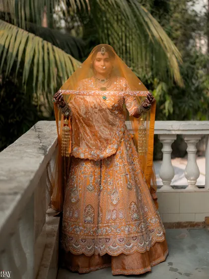 A powerful portrait of the bride holding her veil, looking regal and poised.
