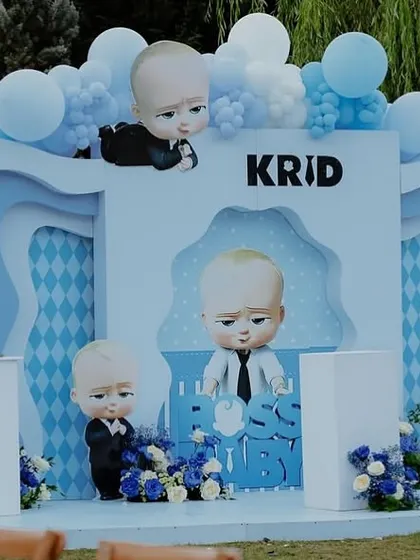 A close-up of the Boss Baby themed stage, showing the detailed character props and the layered blue backdrop.
