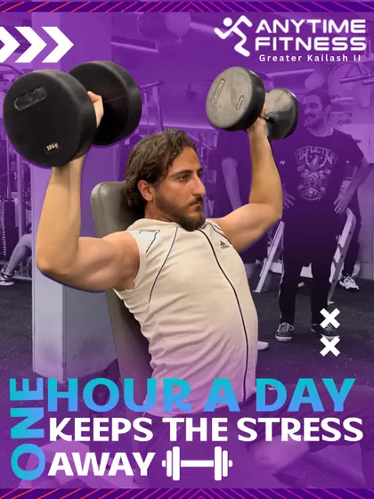 One hour a day keeps the stress away. A member performs a dumbbell shoulder press, building upper body strength.