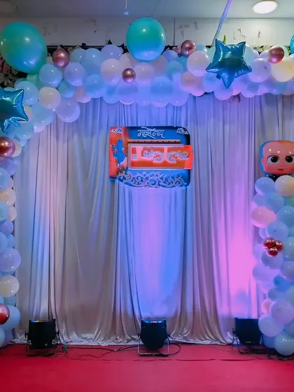 A Boss Baby themed balloon arch for a naming ceremony, with blue uplighting creating a special ambiance.