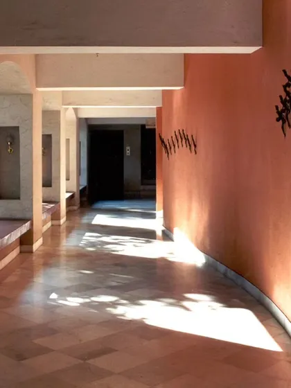 The play of dappled sunlight along the corridor of the Ayushakti Health Resort, demonstrating how we use architecture to create dynamic and calming interior experiences.