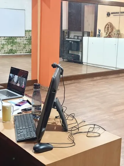 The instructor's desk during a hybrid class, equipped with multiple screens to manage both sets of students effectively.