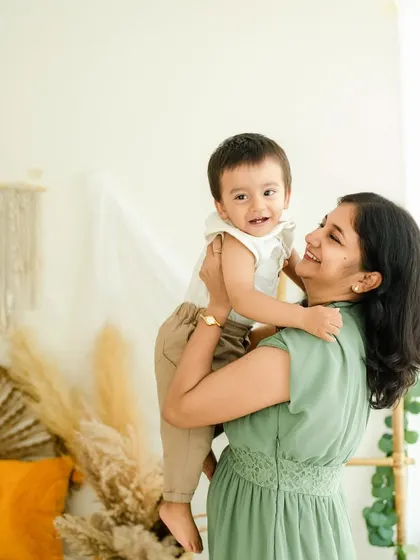 A mother lifts her son, and both their faces light up with smiles. This is a perfect example of the joyful, interactive moments I love to capture during a mother and son photoshoot.