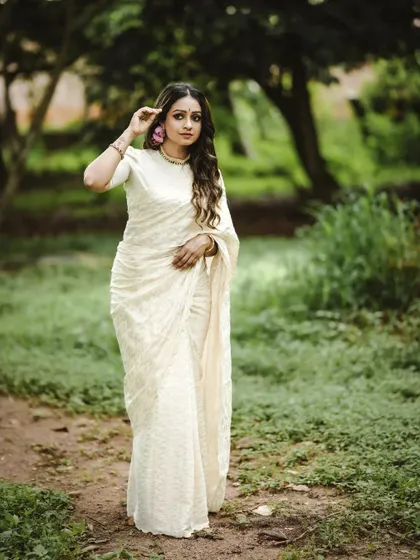 Another beautiful shot from the Onam fashion series. The full-length view captures the complete look, showing how the traditional attire flows gracefully in a natural, green setting.
