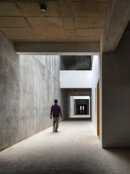 A solitary figure walks through a light-filled corridor at MSAP, highlighting the human scale within the monumental architecture.