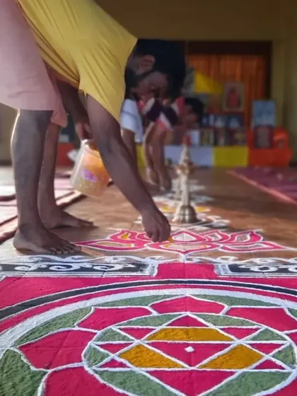 A student carefully adds details to the large, colorful rangoli. This collective effort builds a sense of community and shared purpose.