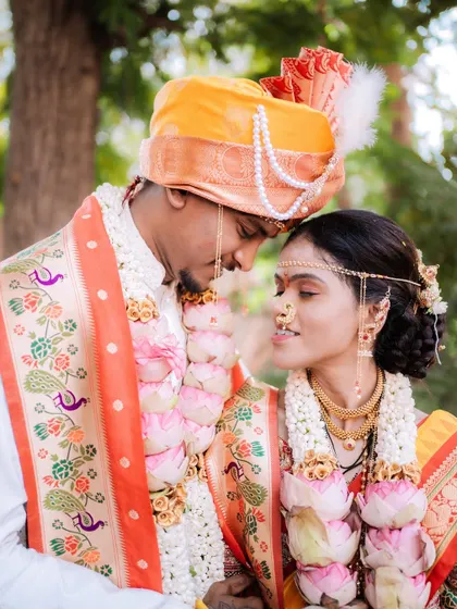 An intimate close-up capturing the delicate details of the 'mundavalya' as the couple shares a quiet moment.