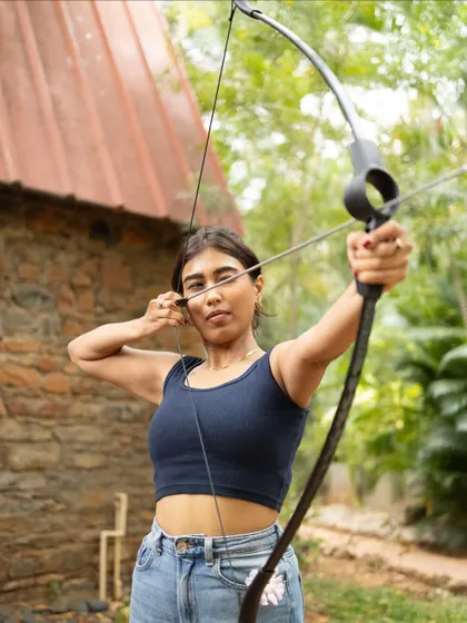 With the bow drawn and target in sight, a guest demonstrates focus and form. Our instructors are on hand to help you perfect your archery technique.