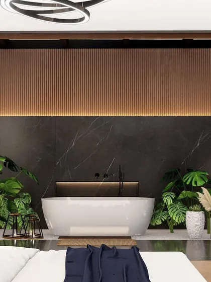 A view from the bed looking into the integrated bathroom area. The freestanding tub is the centerpiece, set against a black marble wall and accented with warm wood paneling and indoor plants.