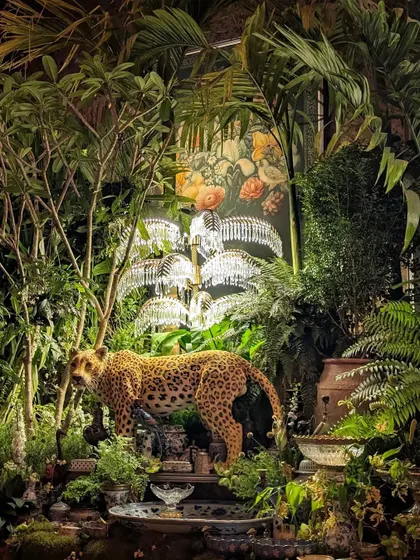 A stunning composition from the Sabyasachi event, where a leopard statue is nestled within a jungle of palms and Frangipani trees. The scene is illuminated by crystal palm tree lamps, blending our greenery with the event's luxurious design elements.