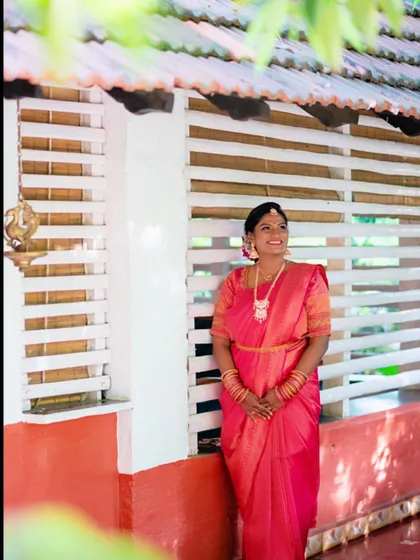 The bride in her beautiful pink Muhurtham saree. The makeup features a subtle cut crease with shimmer, adding a touch of modern elegance to a traditional look.