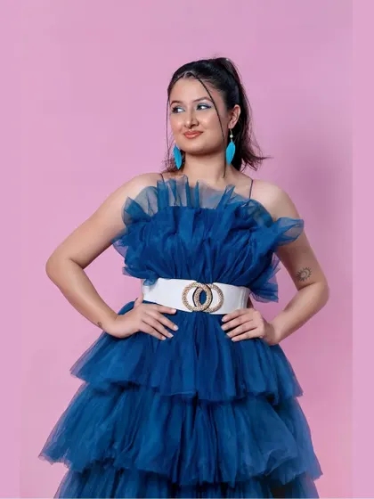 A confident pose in the peacock blue ruffle gown.
