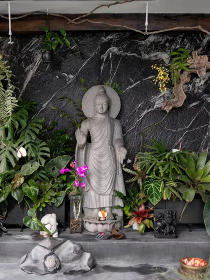 A closer look at the Buddha statue and the lush foliage. This space was a dream to create with our clients, who are passionate plant lovers.