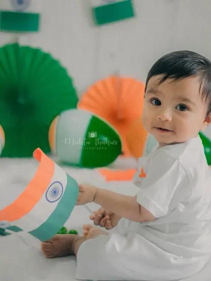 This image captures a sweet interaction between the baby and the flag prop, showcasing his curiosity and gentle nature.