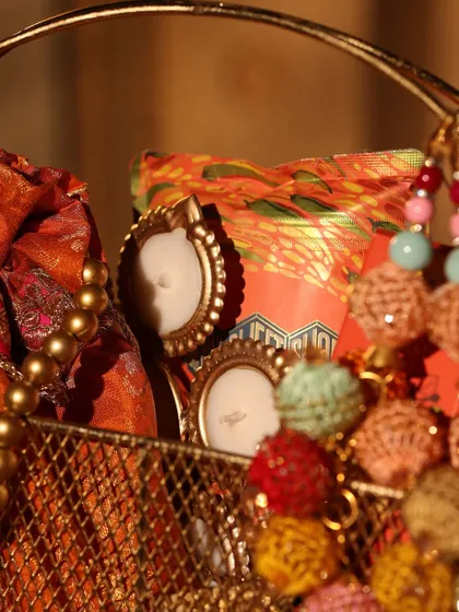 A peek inside the golden Diwali basket, showing mini photo frames and a traditional potli bag, perfect for a classic festive feel.