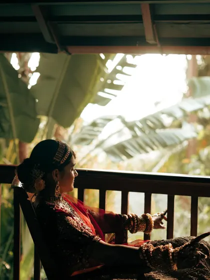 The bride looking out from a balcony, surrounded by the lush greenery of the destination. A beautiful, contemplative shot.