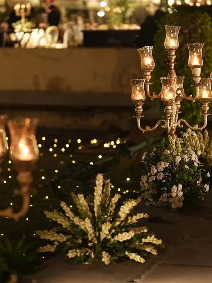 Close-up of the candle-lit pathway, where ornate candelabras and bunches of white flowers create a romantic and luxurious feel.