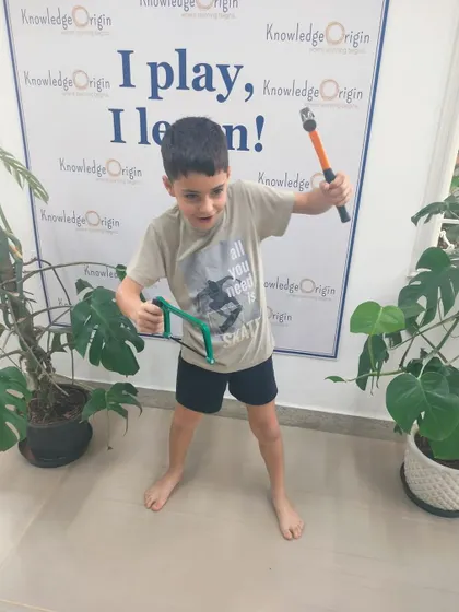 This young builder strikes a dynamic pose with his tools. The energy and excitement are palpable in our STEM camps, where kids are always eager to create.