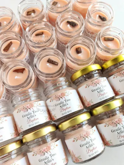 An overhead view of the cinnamon-topped mini jar candles, ready to be packaged for the Baptism celebration.