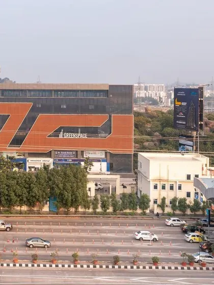 The 'Greenspace' commercial building viewed from the highway, showing its prominence in the urban fabric. The bold facade is designed to be a recognizable landmark for commuters.