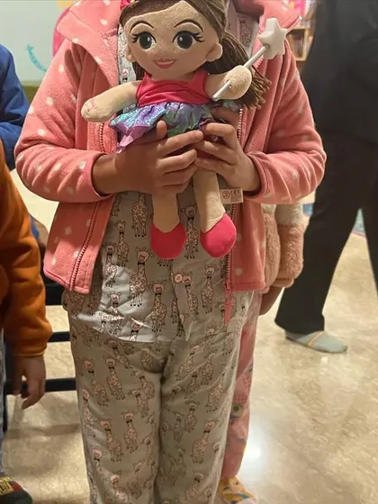 One of our members with her favorite doll at the pajama party. Bringing a toy from home makes the experience even more special.