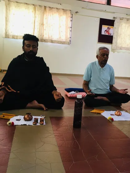 Two participants sitting in meditation after a practice session. The stillness that follows a Hatha Yoga practice is profound. Our space is designed to be a consecrated environment that supports this inward journey.