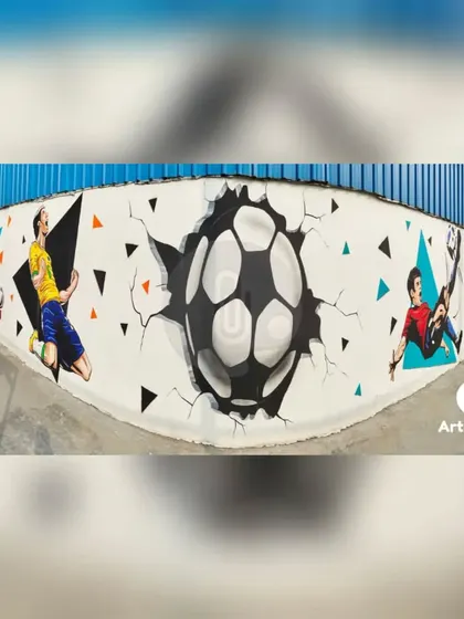 A panoramic shot of the football mural, centered on a dramatic 3D illusion of a soccer ball breaking through the wall. This serves as an incredible centerpiece for the sports ground.
