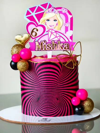 For this fun Barbie-themed cake, I created a mind-bending illusion effect using only buttercream. The vibrant pink and black spiral design is a great example of how we can play with patterns to create something unexpected and cool.