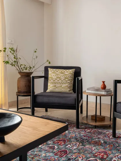 A cozy corner in the living room, where modern furniture and a traditional rug create a comfortable and stylish seating area.