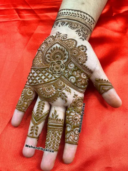 Beauty in every stroke. This Arabic-style design flows beautifully across the hand, with intricate details on the fingers and a central floral motif.