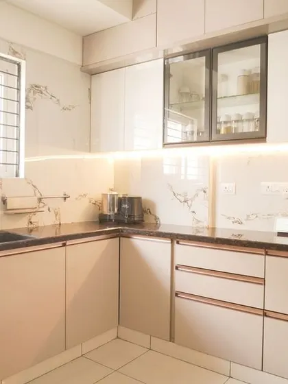 This view shows the efficient layout of the U-shaped kitchen, with ample counter space and storage. The marble-patterned backsplash adds a layer of sophistication and is easy to clean.