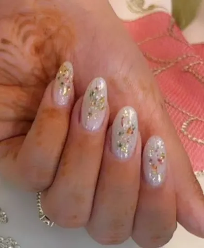 A delicate and shimmery set with a sheer white base and scattered flecks of colorful, dried-flower confetti.